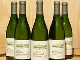 quatre bouteilles de vin sont alignées sur un tonneau en bois