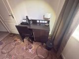 a desk with two chairs and a lamp in the corner