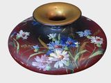 a red vase with blue and white flowers painted on it