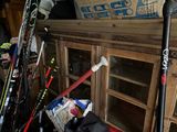many skis and ski poles on the floor in a room