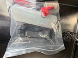 a plastic bag filled with a bottle of water and a red handle