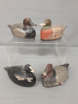 trois canards sont posés sur une vitrine transparente posée sur une table