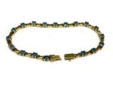 un gros plan d'un bracelet orné de pierres bleues sur fond blanc