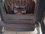 a stove with a wood burning in it on a tiled floor