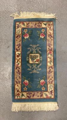 un tapis oriental représentant un oiseau et des fleurs sur fond bleu