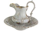a white pitcher and a saucer sitting on a plate