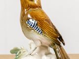a figurine of a bird sitting on a branch