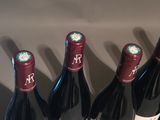 four bottles of wine are lined up on a table