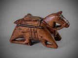 an old wooden horse with a saddle on it ' s back