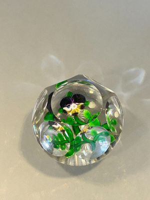 a glass object with flowers inside of it on a table