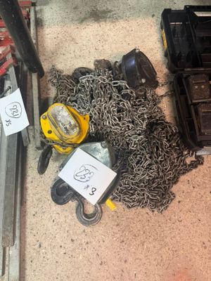 un tas de chaînes par terre, à côté d'une boîte à outils