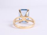 an image of a gold ring with a blue topaz stone