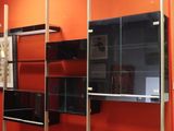 un salon avec un canapé et une télévision accrochée au mur