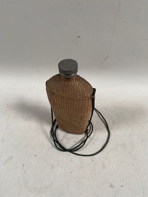 une bouteille posée sur une table, avec un cordon