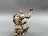 statue of a man with a sword on a pedestal on a gray background