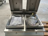 une photo montrant deux casseroles en acier inoxydable posées sur une palette en bois