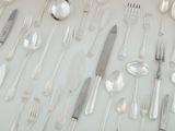 a lot of silver spoons and forks on the table