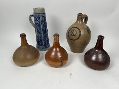 Plusieurs types de vases sont alignés sur une surface blanche