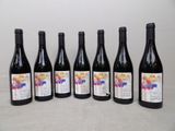 six bouteilles de vin sont alignées sur une table