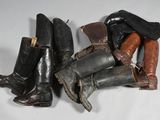 several pairs of boots are lined up on a white surface