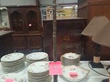 beaucoup d'assiettes et une lampe posées sur une table