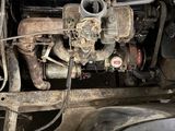 a dirty engine in the back of an old car