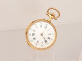 une montre de poche en or avec des chiffres romains