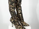 un gros plan sur une paire de bottes à talons hauts posées sur un socle