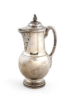 une cafetière ancienne en argent posée sur un support, sur fond blanc