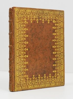 a brown and gold book sitting on top of a white table