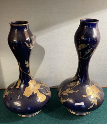 two blue vases with gold designs on them