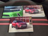 two open crossland brochures sitting on top of a car seat
