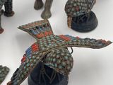 several figurines of animals and birds are displayed on a white surface