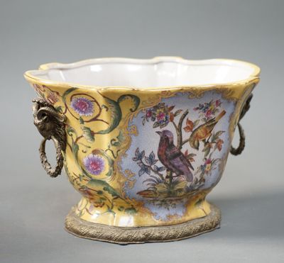 un vase jaune orné d'un oiseau et de fleurs