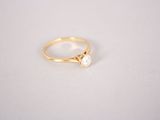 a gold ring with a single diamond on top of it