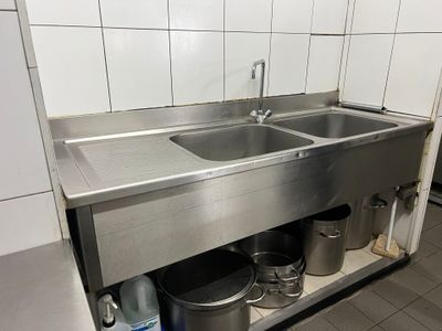 un évier en acier inoxydable au milieu d'une cuisine