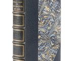 un vieux livre à la couverture bleue posé sur une surface blanche