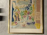 un tableau accroché au mur à côté d'un vase de fleurs
