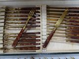 many forks and spoons in a box on a table