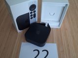 une Apple TV posée sur une table à côté d'un boîtier