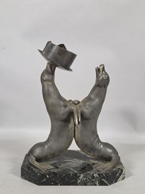 statue of two bears with hats on their heads on a marble base