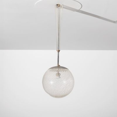 un gros plan d'un plafonnier avec une boule de verre suspendue au plafond
