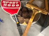 une raquette de tennis et quelques balles dans un seau