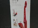 packaging of a red vacuum cleaner sitting on top of a wooden table