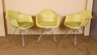 trois chaises jaunes placées les unes à côté des autres sur un sol recouvert de moquette