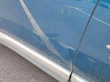 a car that has a broken door handle on the side of the road