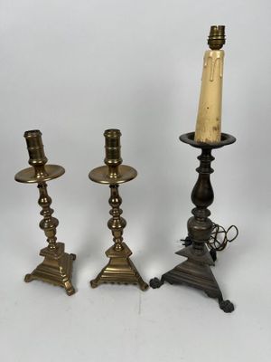 trois bougeoirs en laiton et un porte-bougie sur fond blanc