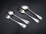 three silver spoons and a fork on a black surface