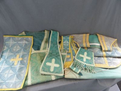 plusieurs gilets verts et jaunes ornés de croix, posés sur une table