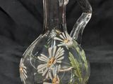 un vase en verre contenant des fleurs, sur fond noir
